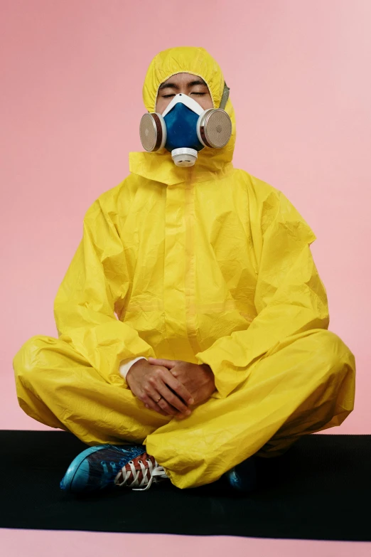 a man in a yellow hazmat suit sitting on a yoga mat, inspired by Martin Schoeller, pexels, dust mask, biopunk suit, promotional image, crime scene