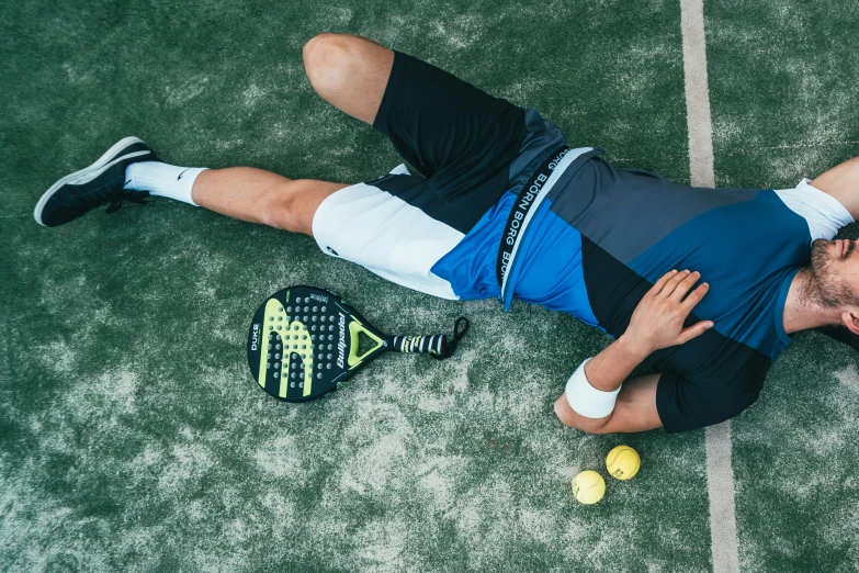 a man laying on the ground with a tennis racket, knee pads, passed out, jovana rikalo, spasms