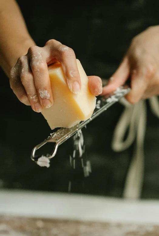 a person using a grater to grate cheese, pexels, carved soap, thumbnail, holding a crowbar, splash image