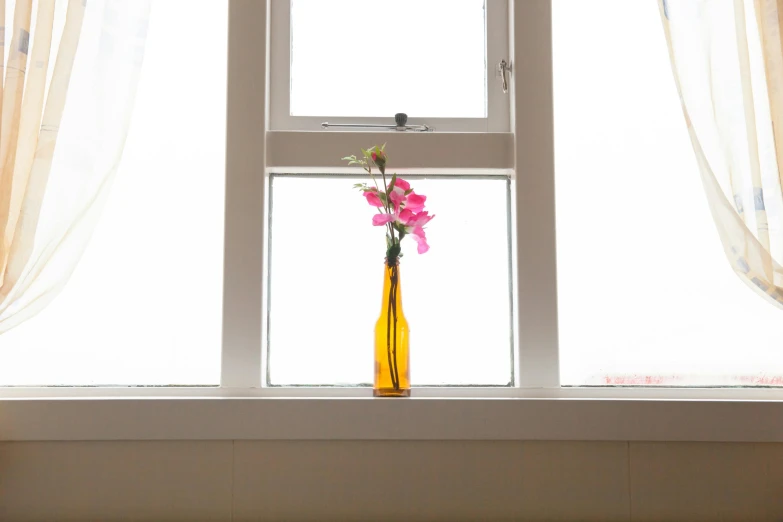 a yellow vase with pink flowers sitting in front of a window, inspired by Anna Ancher, unsplash, minimalism, glass bottle, side view profile, very thin, low - angle shot