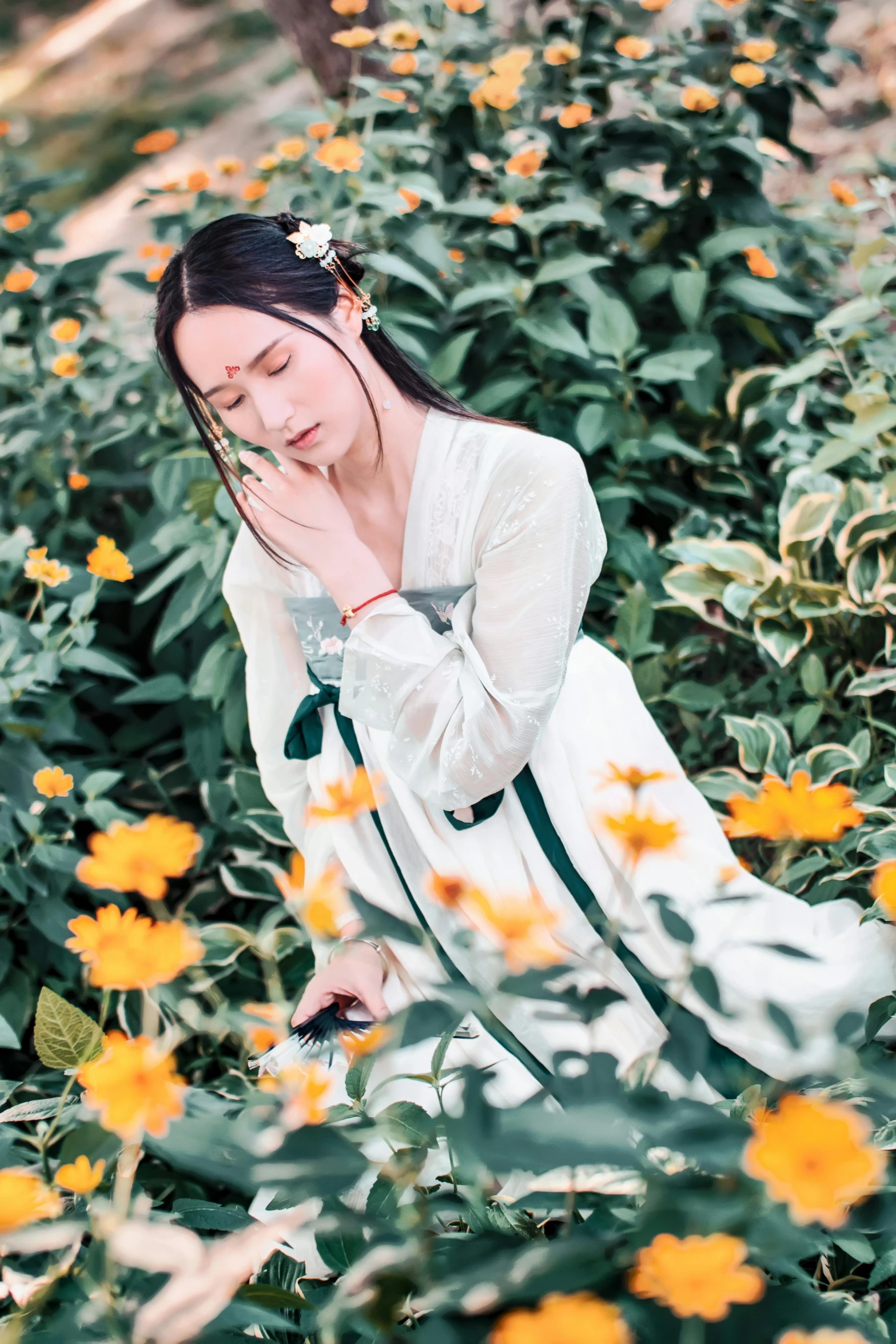 a woman sitting in a field of yellow flowers, inspired by Cui Bai, wearing white silk, li zixin, white sleeves, in a verdant garden