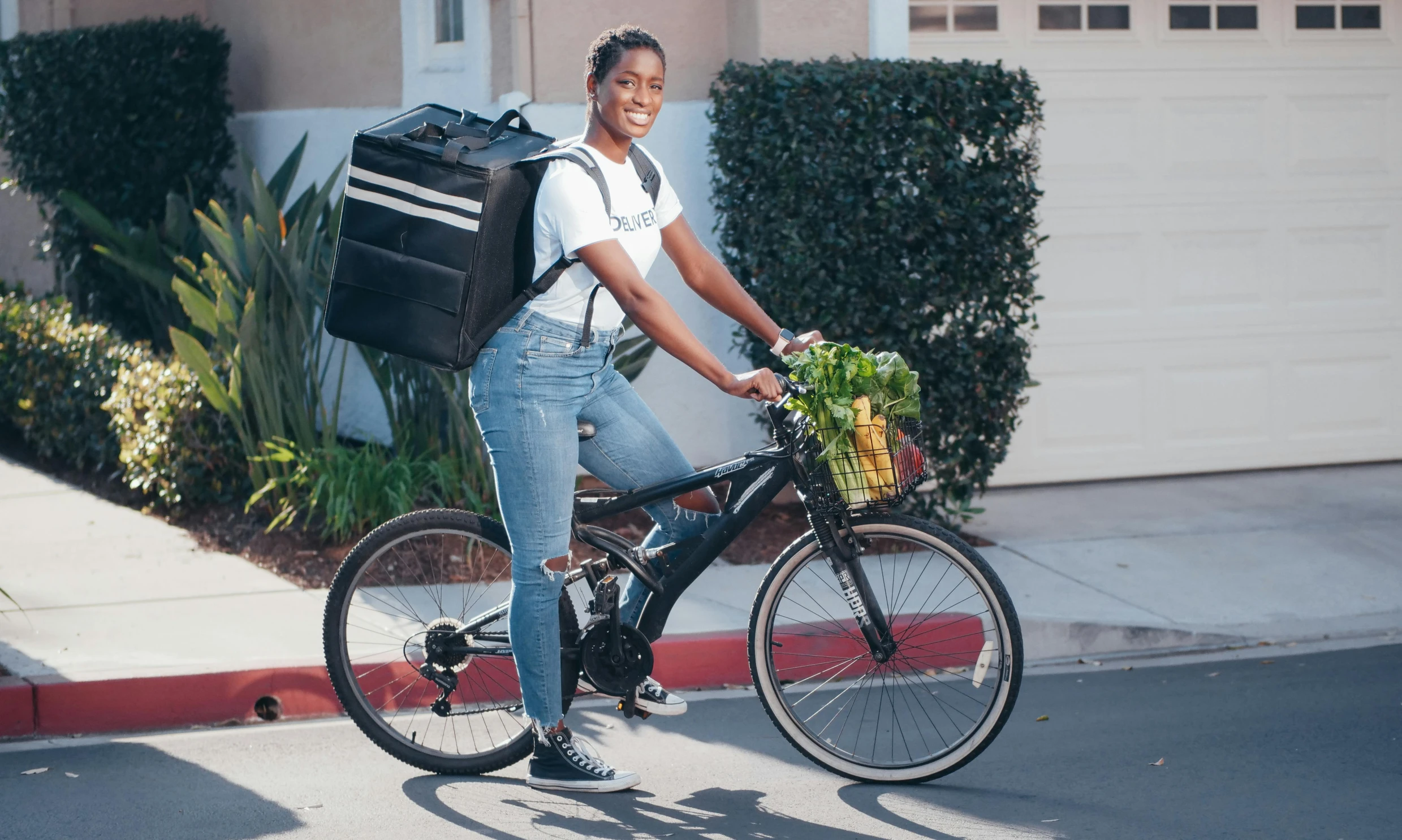 a woman riding a bike with a bag on the back, mkbhd, full body hero, food, front on