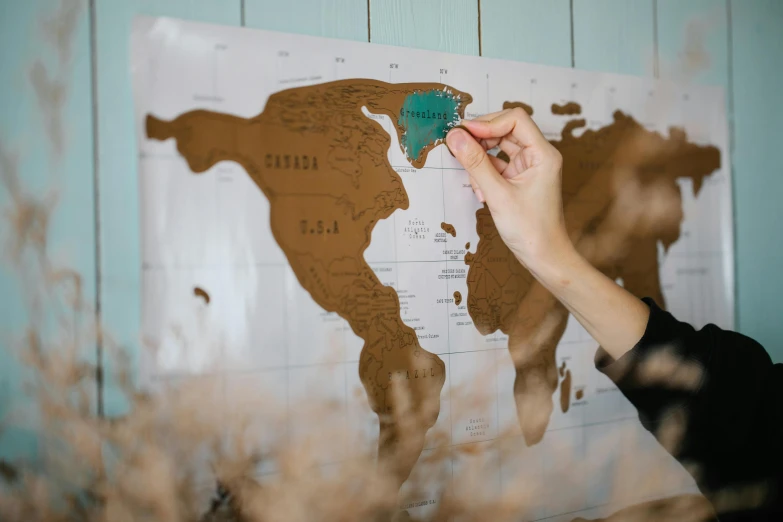 a woman places a pin on a map of the world, an ultrafine detailed painting, pexels contest winner, brown, metallic, uk, modeled