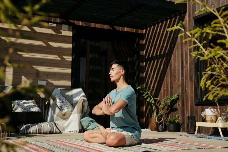 a woman sitting on the ground in a yoga pose, by Carey Morris, pexels contest winner, hurufiyya, a handsome, standing outside a house, praying posture, lachlan bailey