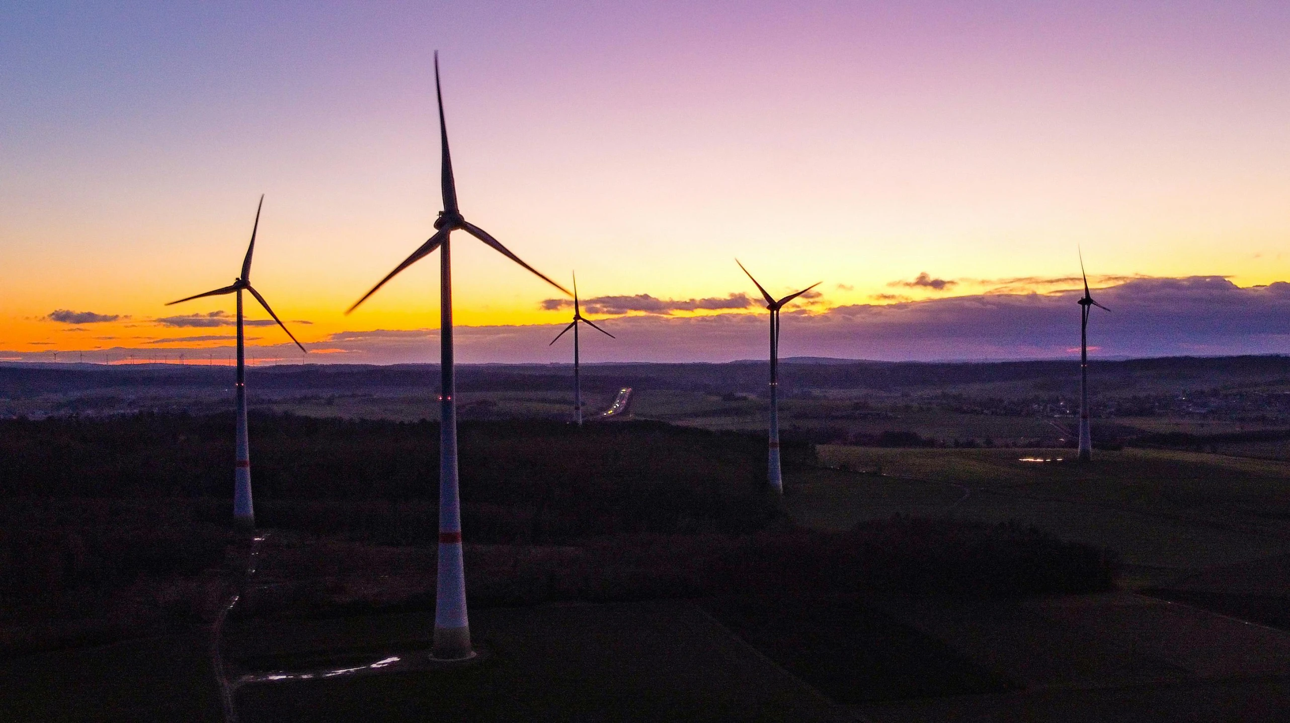 a group of wind turbines sitting on top of a lush green field, a picture, by Jesper Knudsen, pexels contest winner, twilight ray, ultrawide lens”, maintenance photo, electric motors