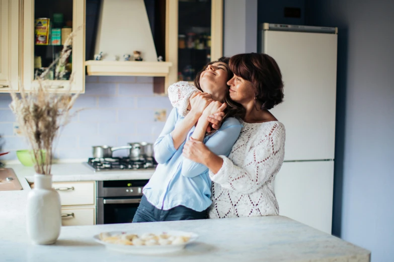 a woman holding a child in a kitchen, pexels contest winner, lesbian embrace, aggressive pose, profile image, beautiful views