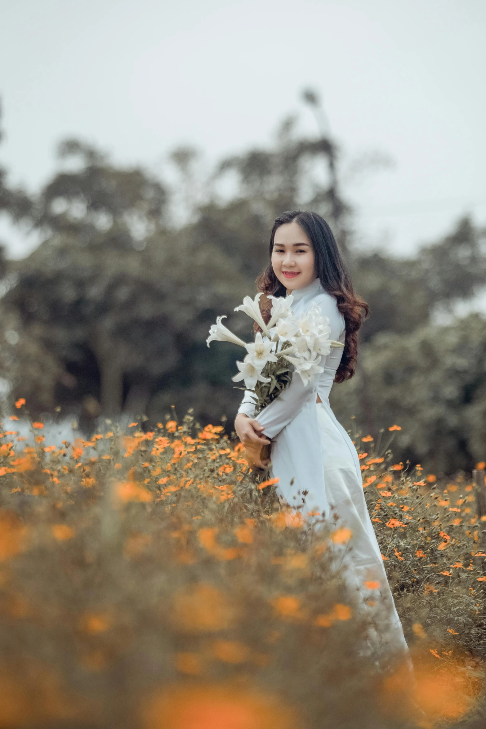 a woman standing in a field of flowers, by Tan Ting-pho, art photography, white and orange, 15081959 21121991 01012000 4k, ao dai, medium format. soft light