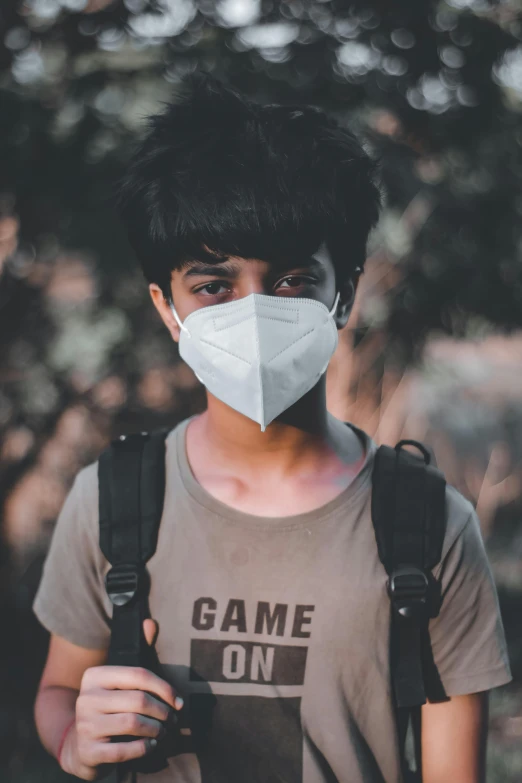 a man wearing a face mask while holding a camera, trending on pexels, game ready, wearing a t-shirt, avatar image, teenage boy