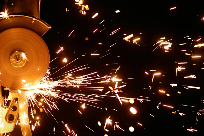 a close up of a person using a grinder, by Matt Cavotta, pexels contest winner, kinetic art, new years eve, steel mill, avatar image