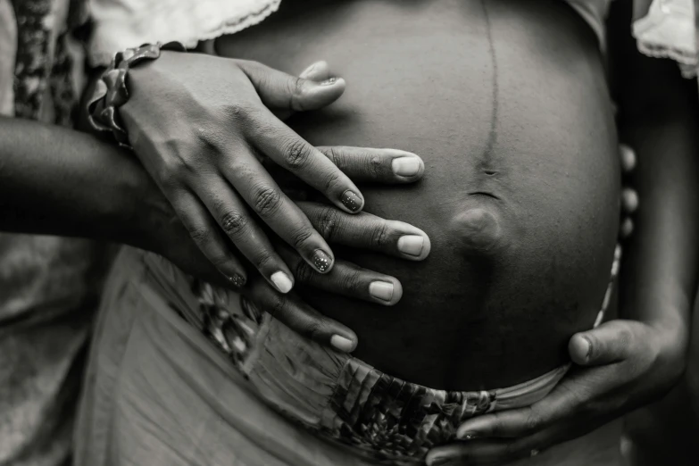 a pregnant woman with her hands on her belly, by Matija Jama, pexels contest winner, malnourished, black an white, precious gems, fatherly