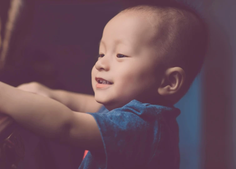 a close up of a child holding a remote control, pexels contest winner, symbolism, handsome chad chin, raising an arm, 2 years old, soft light from the side