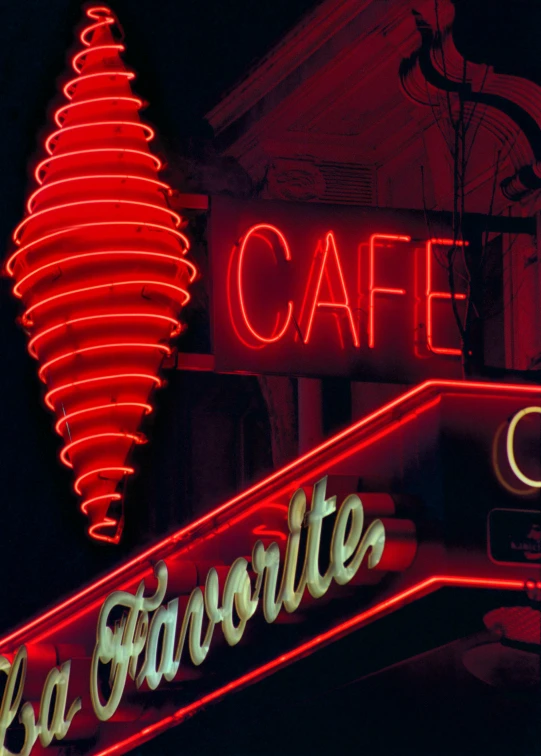 a neon sign on the side of a building, 1960s color photograph, cafe lighting, reds), cone