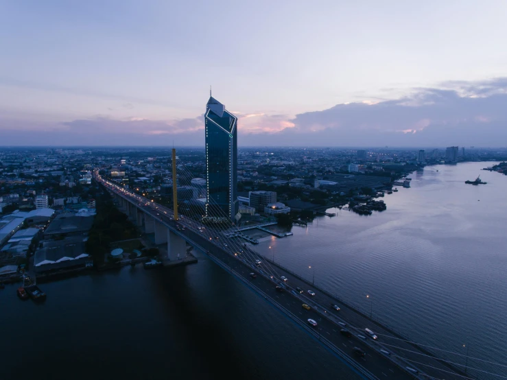 a large bridge over a large body of water, by Adam Marczyński, pexels contest winner, bangkok, aerial footage, at dawn, building in the distance