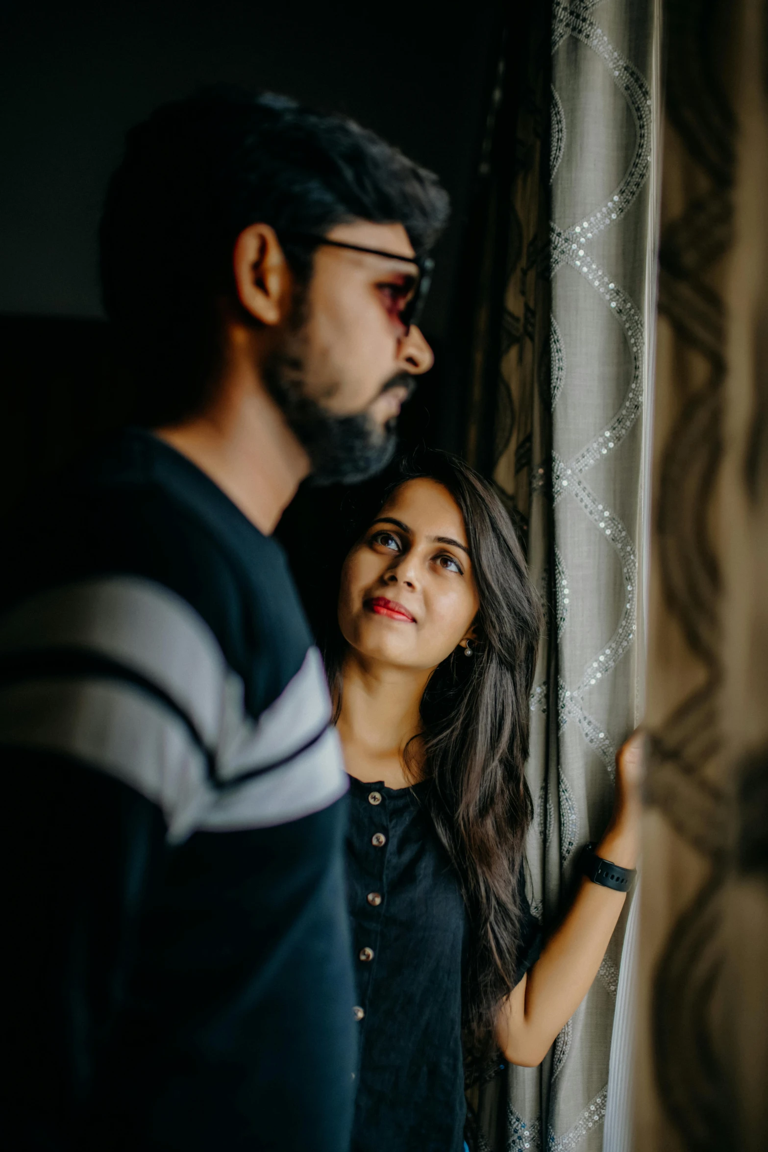 a man and woman looking out a window, by Max Dauthendey, pexels contest winner, jayison devadas, looking to his side, loving stare, with black