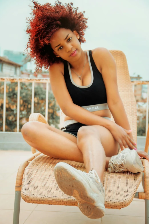 a beautiful young woman sitting on top of a chair, inspired by Kaja Foglio, pexels contest winner, renaissance, sport bra and shorts, natural hair, sneakers, instagram model