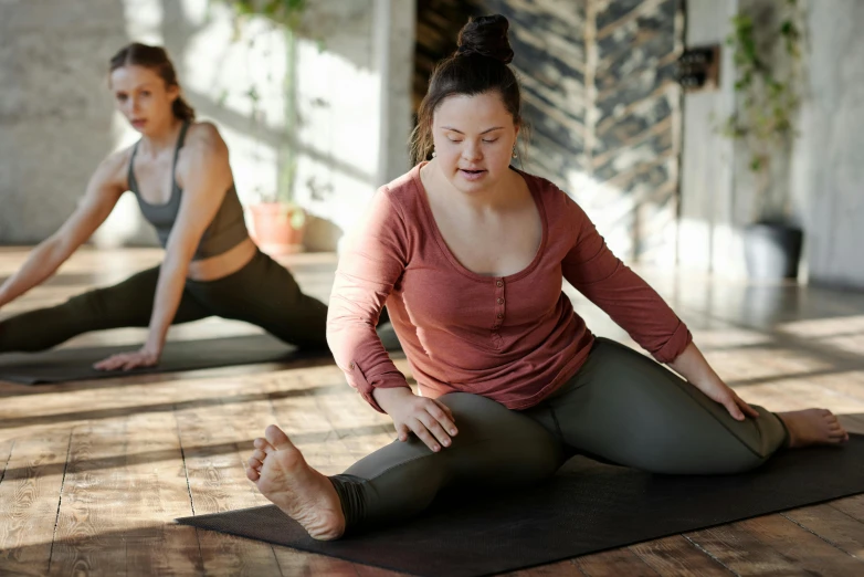 a couple of women sitting on top of a yoga mat, a picture, trending on pexels, hurufiyya, plus-sized, pixeled stretching, brown, looking partly to the left