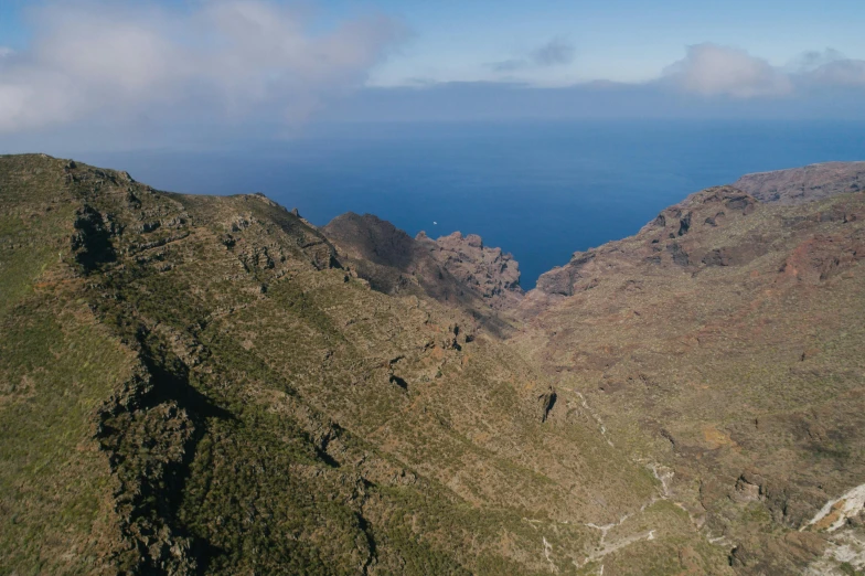 a view of the ocean from the top of a mountain, by Daniel Lieske, pexels contest winner, les nabis, view from helicopter, brown, thumbnail, devils horns