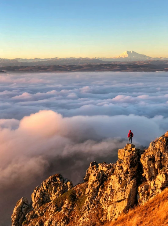 a person standing on top of a mountain above the clouds, chile, high-quality dslr photo”