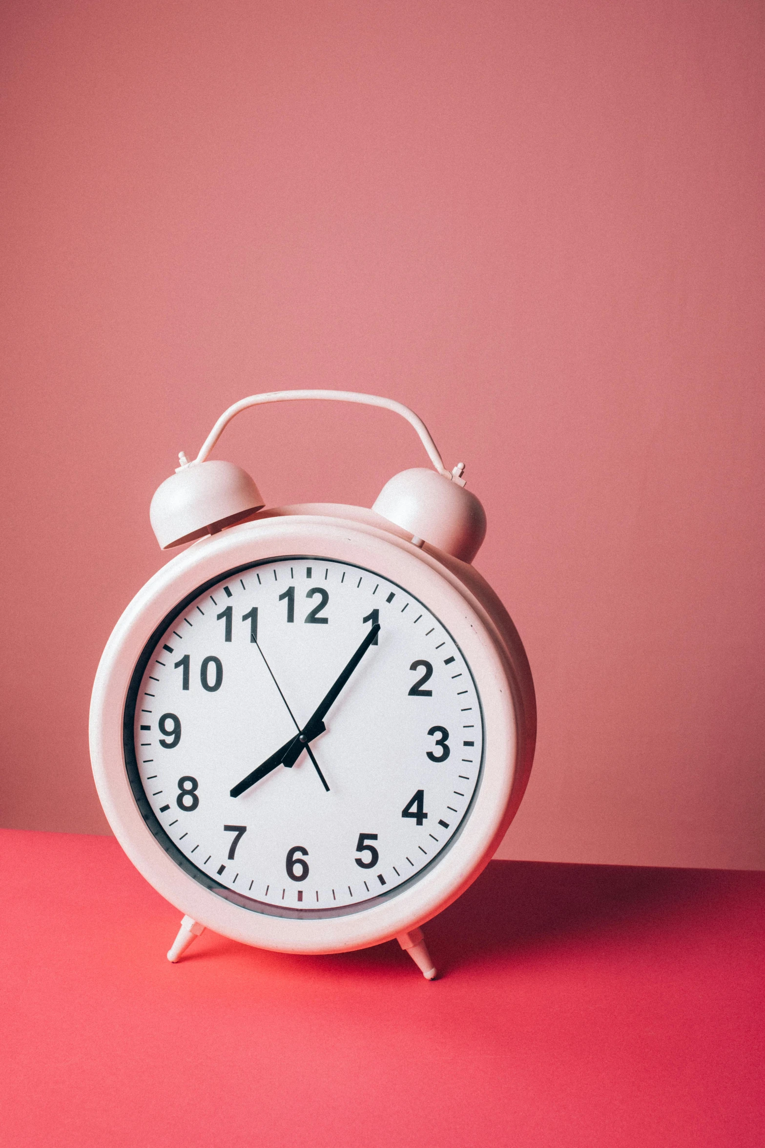 a pink alarm clock sitting on top of a table, thumbnail, high-resolution, time + space + reality, feature