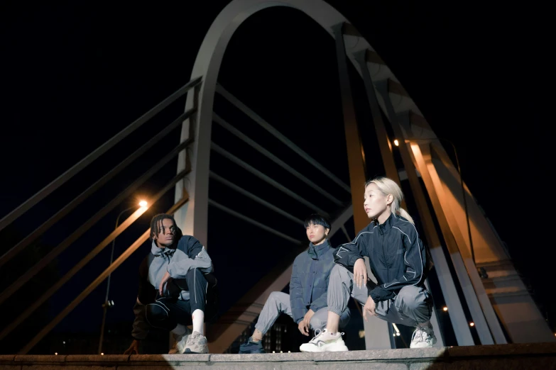 a group of people sitting on top of a bridge, a portrait, inspired by Gang Hui-an, unsplash, realism, techwear clothes, midnight, low quality photo, kpop