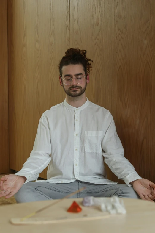 a man that is sitting in the middle of a table, by Nina Hamnett, meditating, wearing a light shirt, ukiyo, neckbeard