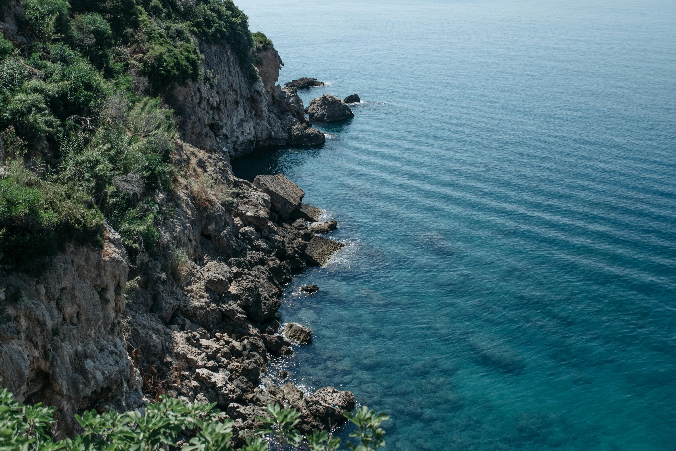 a large body of water next to a cliff, pexels contest winner, picton blue, black sea, lush surroundings, thumbnail