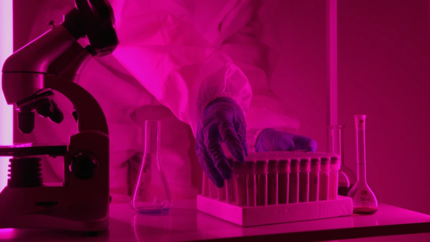 a person in a lab coat is using a microscope, by Daniel Lieske, unsplash, process art, dramatic pink light, magenta, test tubes, volumetric lighting. red