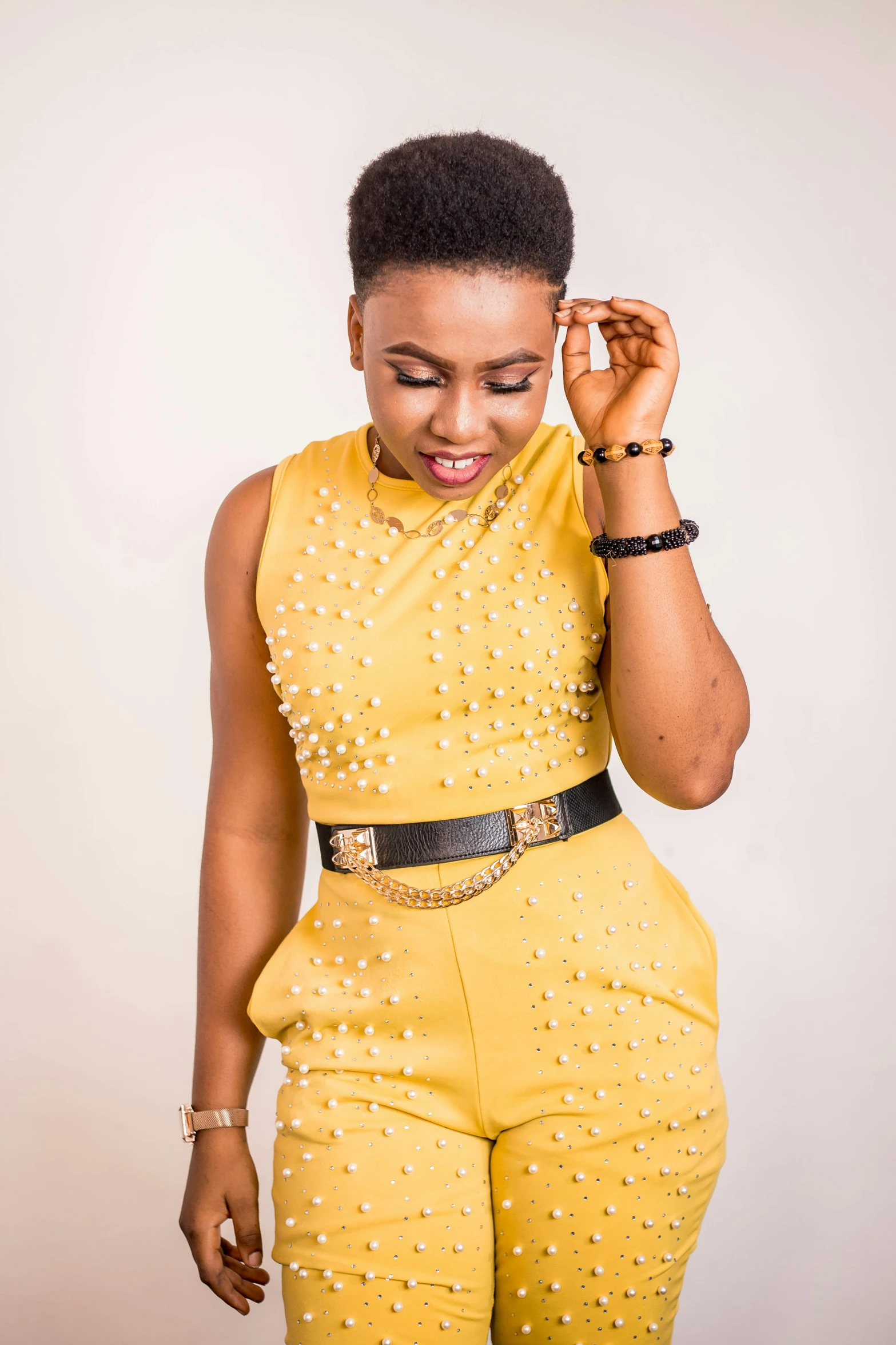 a woman in a yellow top and yellow pants, inspired by Chinwe Chukwuogo-Roy, trending on pexels, wearing studded leather, 15081959 21121991 01012000 4k, elegant smiling pose, jumpsuit