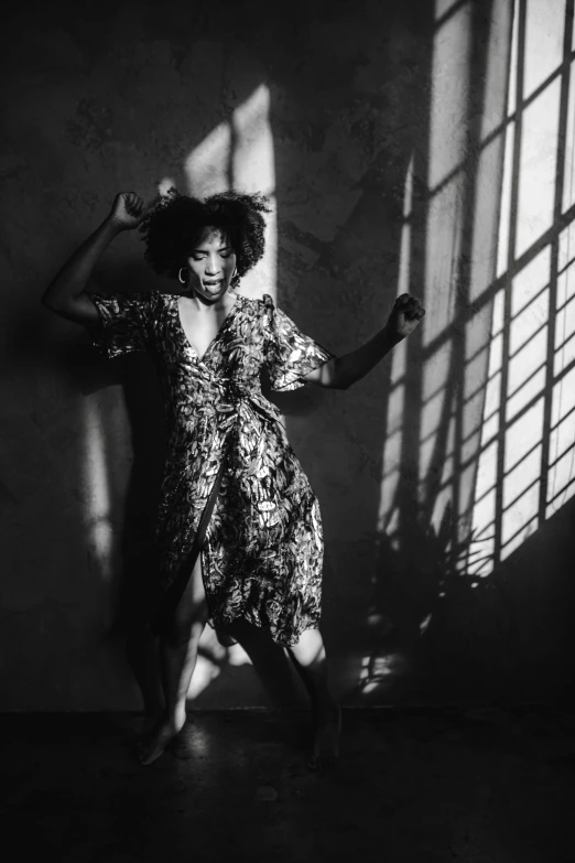 a black and white photo of a woman in a dress, inspired by Carrie Mae Weems, pexels contest winner, baroque, queen in a glass prison, pose(arms up + happy), warm lighting with cool shadows, sza