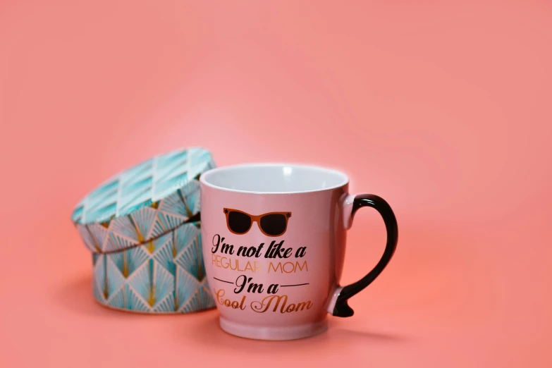 a coffee mug that says i'm not like a regular mom, i'm a real mom, by Elaine Hamilton, photorealism, sunglasses on, multicoloured, middle shot, pink