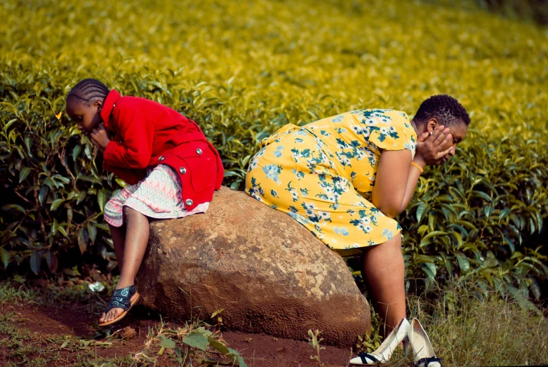 a couple of people that are sitting on a rock, by Daniel Lieske, pexels contest winner, happening, very kenyan, girl sitting in a flower field, embarrassing, tea