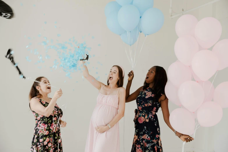 a group of women standing next to each other holding balloons, by Arabella Rankin, pexels contest winner, happening, maternity feeling, avatar image, laughing, blue and pink accents