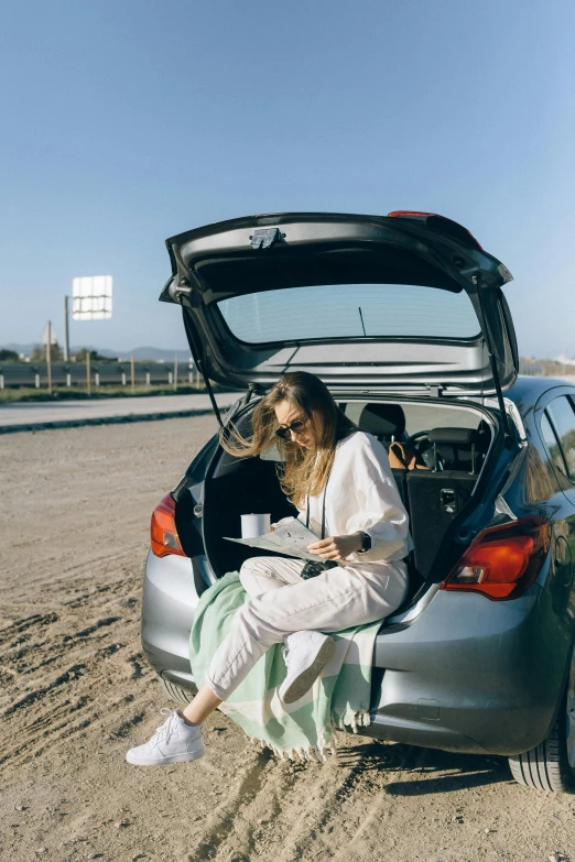 a woman sitting in the trunk of a car, trending on unsplash, happening, studious, square, at the desert, knight of cups