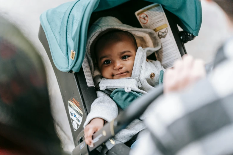 a close up of a baby in a stroller, by Nina Hamnett, happening, highly upvoted, urban surroundings, riyahd cassiem, looking happy