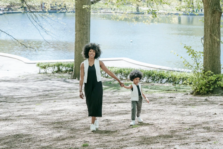 a woman and a child holding hands in a park, an album cover, pexels contest winner, imaan hammam, full body image, parks and lakes, with a white