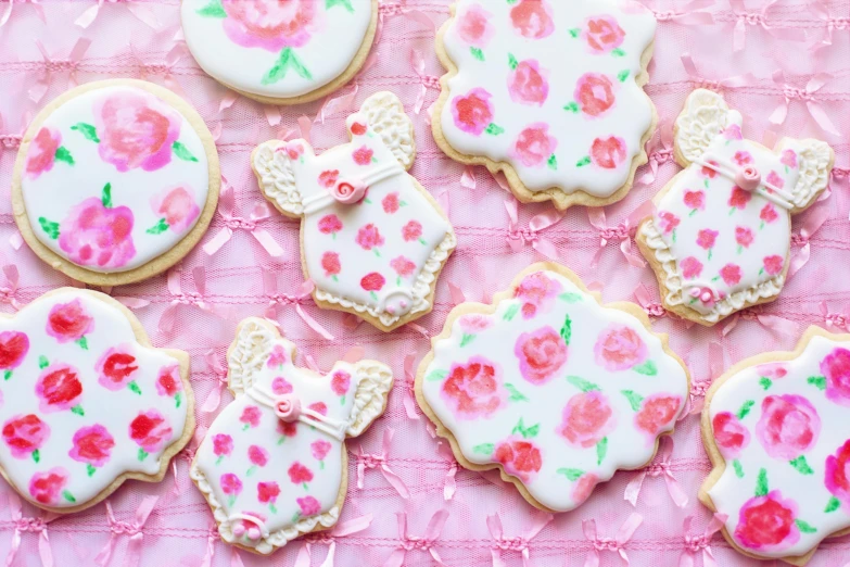 a table topped with lots of decorated cookies, inspired by Annabel Kidston, tumblr, watercolor style, upper body close up, floral patterned skin, white and pink cloth