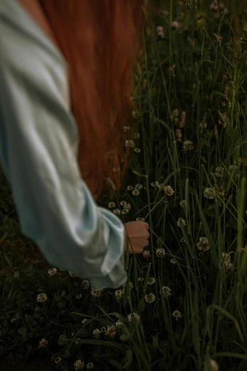a woman standing in a field of tall grass, inspired by Elsa Bleda, trending on unsplash, visual art, holding hands in the moonlight, in a cottagecore flower garden, low detail, softly shadowed