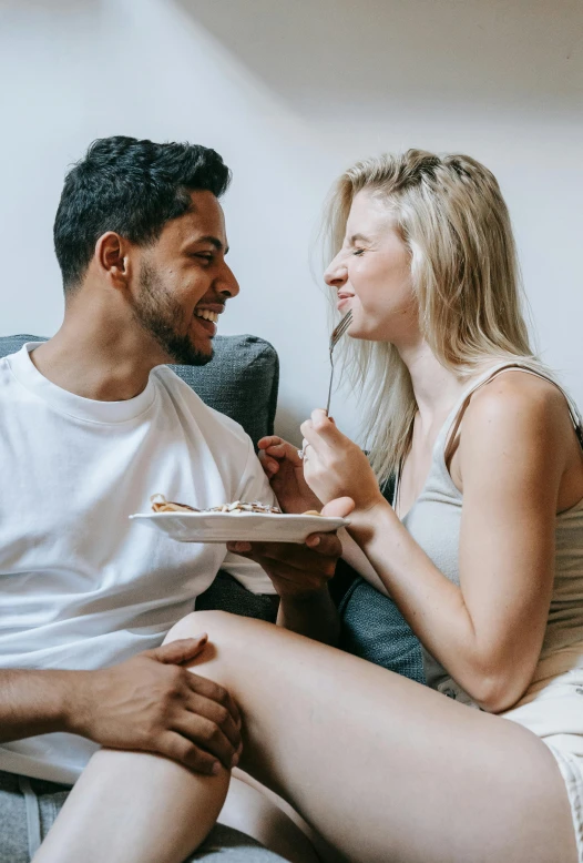 a man and a woman sitting on a couch eating cake, pexels contest winner, renaissance, flirting smiling, blonde guy, on a plate, couple on bed