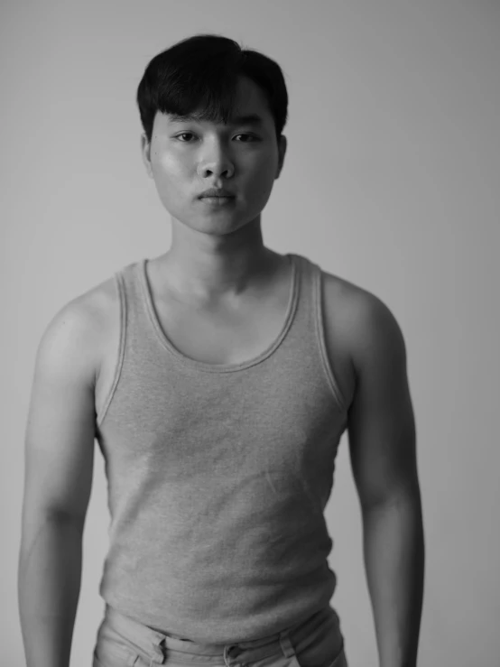 a black and white photo of a man in a tank top, inspired by Joong Keun Lee, lgbtq, yanjun chengt, ((portrait)), young adult male