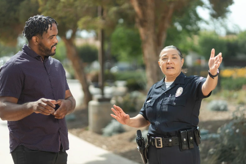 a couple of men standing next to each other on a sidewalk, officer, reaching out to each other, calarts, male and female