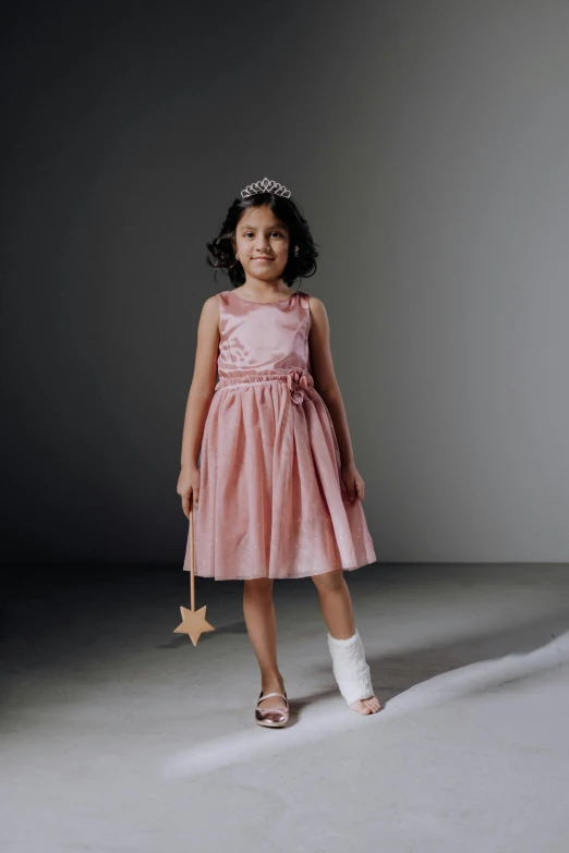 a little girl in a pink dress holding a star, shutterstock contest winner, artificial limbs, formal wear, shot with sony alpha 1 camera, epk