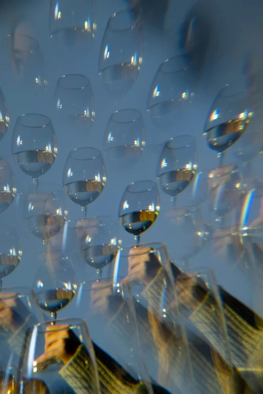 a group of people holding up wine glasses, inspired by Bruce Munro, crystal cubism, photography ultrafine detail, reflected light, pareidolia, fish lense