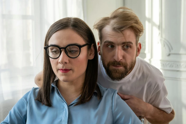 a man standing next to a woman on a couch, trending on reddit, square rimmed glasses, worried, high quality image, hair over her eyes