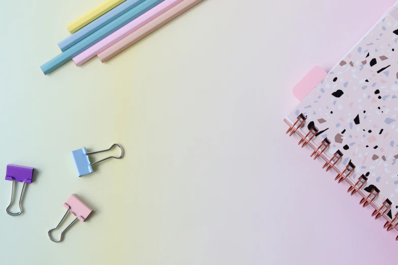 a notebook, paper clips, and pencils on a pastel background, by Rachel Reckitt, trending on pexels, belle delphine, pair of keycards on table, color gradient, background image