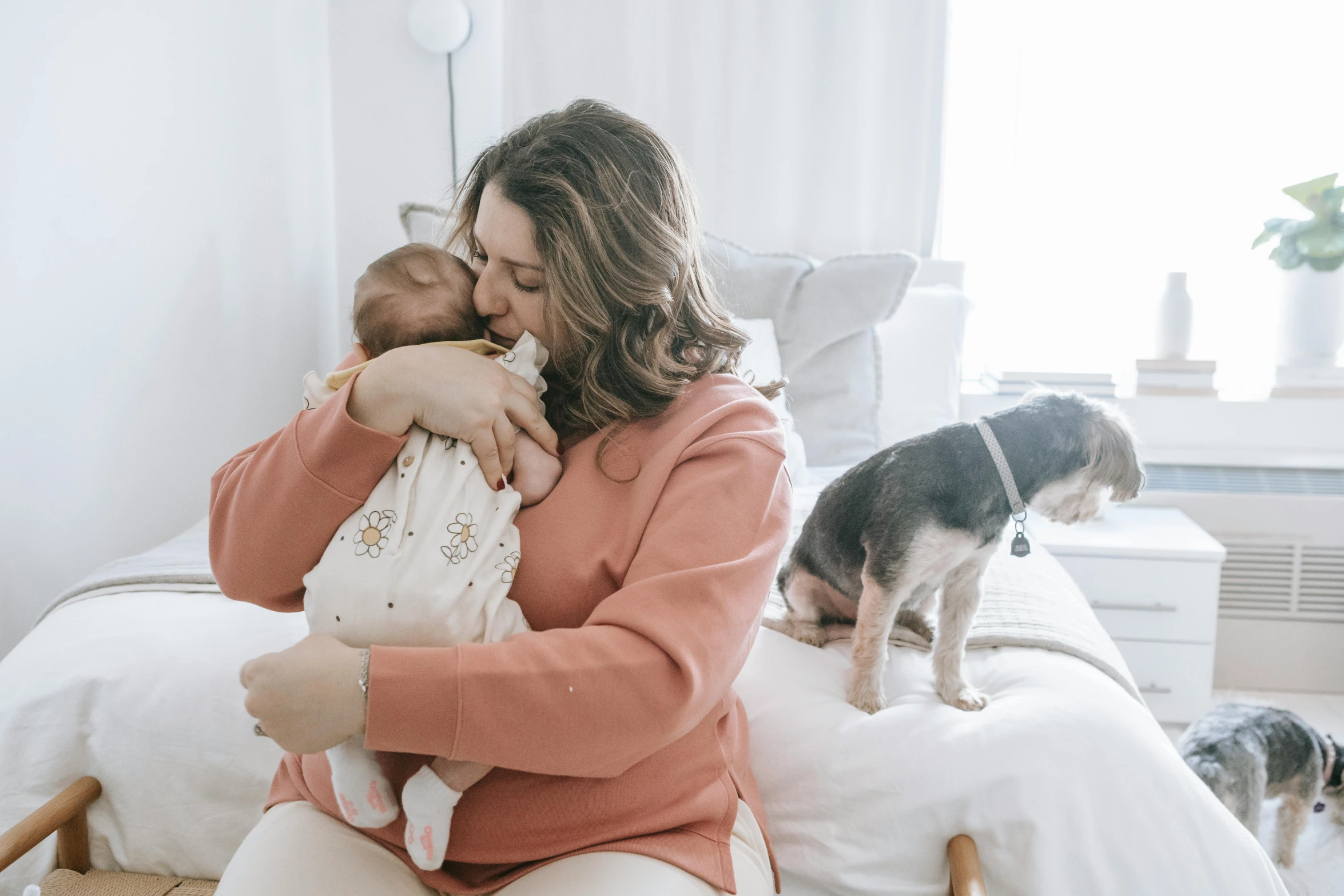 a woman sitting on top of a bed holding a baby, pexels contest winner, animals, profile image, pokimane, holding each other