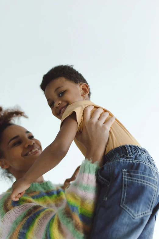 a woman holding a child in her arms, pexels contest winner, willow smith zendaya, plain background, multiple stories, 1 4 9 3