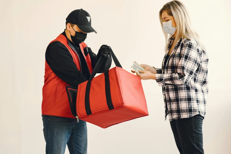 a man in a face mask handing money to a woman in a red vest, pexels contest winner, visual art, logo for lunch delivery, pizza the hut, red and black, full length shot