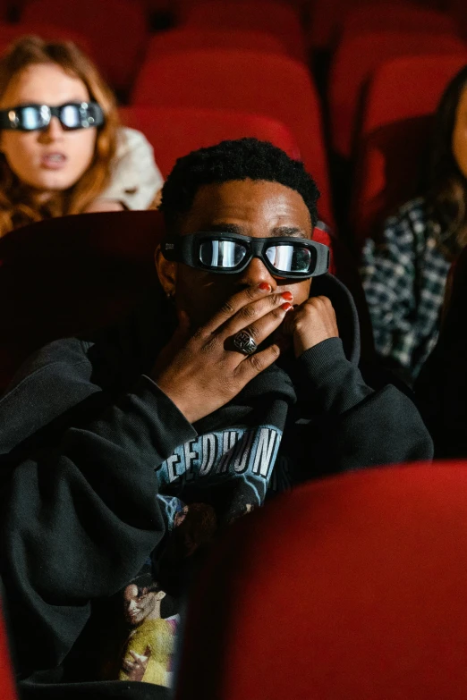 a group of people sitting in a theater wearing 3d glasses, trending on pexels, playboi carti portrait, movie still of a tired, [ theatrical ], slide show