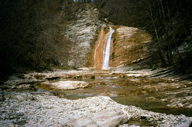 a large waterfall in the middle of a forest, an album cover, unsplash, stephen shore, medium format, nikolay georgiev, 1 9 9 8 photo