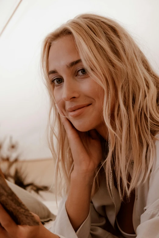 a woman laying on top of a bed next to a cat, a portrait, inspired by Károly Lotz, trending on pexels, wavy blond hair, tanned beauty portrait, sitting down casually, gif
